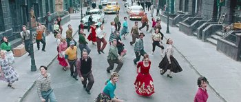 Movie still from “Beyond the Sea” (2004), directed by Kevin Spacey – A group of people are dancing on the street; Wide shot, High angle