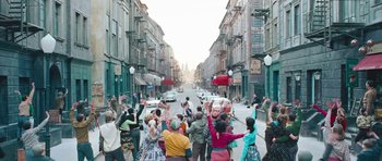 Movie still from “Beyond the Sea” (2004), directed by Kevin Spacey – A group of people standing on the side of a street; Wide shot, High angle