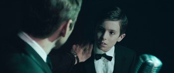 Movie still from “Beyond the Sea” (2004), directed by Kevin Spacey – A young man adjusting the collar of a young man's tuxedo; Close Up shot, Over the shoulder angle
