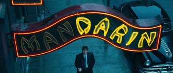 Movie still from “Beyond the Sea” (2004), directed by Kevin Spacey – A man in a suit and hat standing in front of a neon sign; Wide shot, Overhead angle