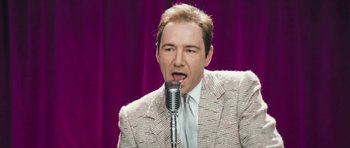 Movie still from “Beyond the Sea” (2004), directed by Kevin Spacey – A man in a suit and tie is singing into a microphone; Close Up shot, High angle