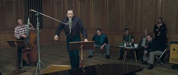 Movie still from “Beyond the Sea” (2004), directed by Kevin Spacey – A man standing in front of two other men; Medium shot, Low angle