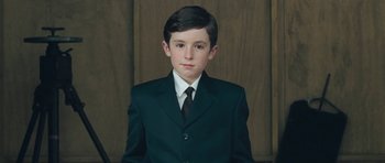 Movie still from “Beyond the Sea” (2004), directed by Kevin Spacey – A young boy in a suit and a tie; Medium shot, High angle