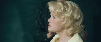 Movie still from “Beyond the Sea” (2004), directed by Kevin Spacey – A woman with blonde curly hair sitting in a chair; Close Up shot, Over the shoulder angle
