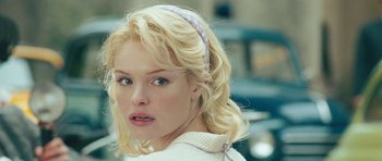 Movie still from “Beyond the Sea” (2004), directed by Kevin Spacey – A woman with blonde hair wearing a white shirt and a purple headband; Close Up shot, Over the shoulder angle