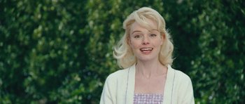 Movie still from “Beyond the Sea” (2004), directed by Kevin Spacey – A woman with blonde curly hair and a checkered dress; Close Up shot, Over the shoulder angle