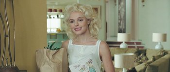 Movie still from “Beyond the Sea” (2004), directed by Kevin Spacey – A woman with blonde hair holding a paper bag; Medium shot, Over the shoulder angle