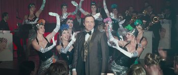 Movie still from “Beyond the Sea” (2004), directed by Kevin Spacey – A man in a suit standing in front of a group of women; Medium shot, Over the shoulder angle