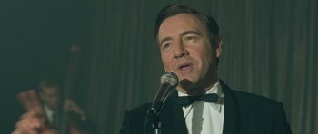 Movie still from “Beyond the Sea” (2004), directed by Kevin Spacey – A person wearing a suit and a bow tie; Close Up shot, Low angle
