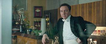 Movie still from “Beyond the Sea” (2004), directed by Kevin Spacey – A man in a tuxedo sitting in a chair; Close Up shot, Low angle