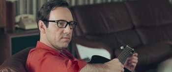 Movie still from “Beyond the Sea” (2004), directed by Kevin Spacey – A man sitting in front of an electric guitar; Close Up shot, Over the shoulder angle