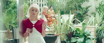 Movie still from “Beyond the Sea” (2004), directed by Kevin Spacey – A woman holding a wine glass in front of a man and woman; Medium shot, Over the shoulder angle