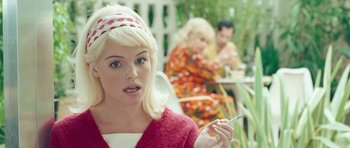 Movie still from “Beyond the Sea” (2004), directed by Kevin Spacey – A young woman holding a cigarette in front of two other women; Close Up shot, Over the shoulder angle