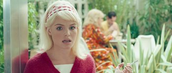 Movie still from “Beyond the Sea” (2004), directed by Kevin Spacey – A woman with blonde hair wearing a red sweater and a polka dot headband; Close Up shot, Over the shoulder angle