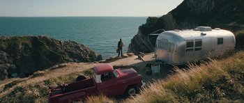 Movie still from “Beyond the Sea” (2004), directed by Kevin Spacey – A man standing next to an old red truck; Wide shot, High angle