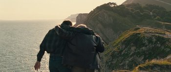 Movie still from “Beyond the Sea” (2004), directed by Kevin Spacey – Two people hugging on a cliff overlooking the ocean; Wide shot, High angle