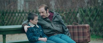 Movie still from “Beyond the Sea” (2004), directed by Kevin Spacey – A man sitting next to a young boy on a bench; Close Up shot, Over the shoulder angle