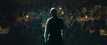 Movie still from “Beyond the Sea” (2004), directed by Kevin Spacey – A man standing in front of a crowd of people; Medium shot, Over the shoulder angle