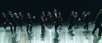 Movie still from “Beyond the Sea” (2004), directed by Kevin Spacey – A group of men in tuxedos dancing on a dance floor; Wide shot, High angle