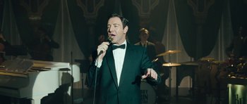 Movie still from “Beyond the Sea” (2004), directed by Kevin Spacey – A man in a tuxedo singing into a microphone in front of a band; Medium shot, Low angle