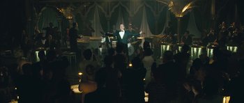 Movie still from “Beyond the Sea” (2004), directed by Kevin Spacey – A group of people in a room with a man in a tuxedo; Wide shot, High angle