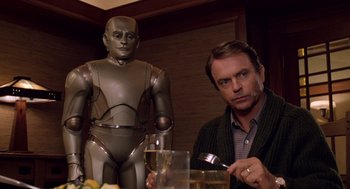 Movie still from “Bicentennial Man” (1999), directed by Chris Columbus – A man sitting at a table next to a robot; Medium shot, Over the shoulder angle