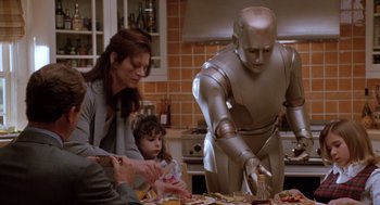 Movie still from “Bicentennial Man” (1999), directed by Chris Columbus – A person in a kitchen with people and a robot; Medium shot, High angle