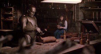 Movie still from “Bicentennial Man” (1999), directed by Chris Columbus – A woman sitting in front of a robot in a workshop; Medium shot, Low angle