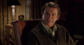 Movie still from “Bicentennial Man” (1999), directed by Chris Columbus – A person sitting in a chair wearing a jacket; Close Up shot, Over the shoulder angle