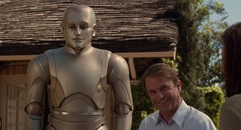 Movie still from “Bicentennial Man” (1999), directed by Chris Columbus – A man standing in front of a robot statue; Medium shot, Over the shoulder angle