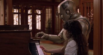 Movie still from “Bicentennial Man” (1999), directed by Chris Columbus – A woman sitting at a piano next to a robot; Medium shot, High angle