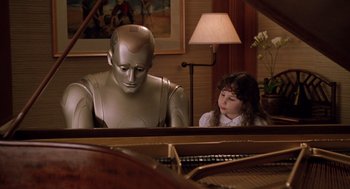 Movie still from “Bicentennial Man” (1999), directed by Chris Columbus – A girl sitting at a piano with a robot sitting next to it; Medium shot, High angle