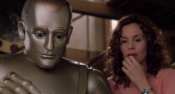 Movie still from “Bicentennial Man” (1999), directed by Chris Columbus – A woman standing next to a robot with one hand in her mouth; Close Up shot, Low angle