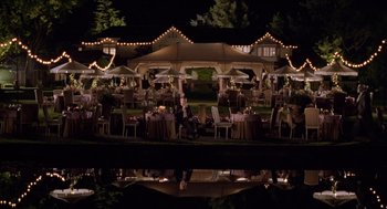 Movie still from “Bicentennial Man” (1999), directed by Chris Columbus – A man sitting on the ground in front of a restaurant; Extreme Wide shot, High angle