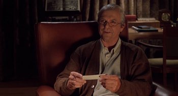 Movie still from “Bicentennial Man” (1999), directed by Chris Columbus – An older man sitting in a chair holding a piece of wood; Close Up shot, Over the shoulder angle