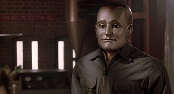 Movie still from “Bicentennial Man” (1999), directed by Chris Columbus – A man in a brown jacket is standing in front of a brick wall; Close Up shot, Over the shoulder angle