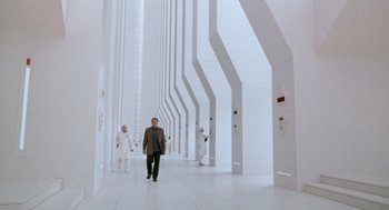 Movie still from “Bicentennial Man” (1999), directed by Chris Columbus – A man walking down a long white hallway; Extreme Wide shot, Low angle
