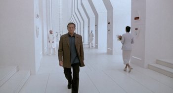 Movie still from “Bicentennial Man” (1999), directed by Chris Columbus – A man walking down a hallway in a room; Wide shot, Low angle
