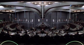 Movie still from “Bicentennial Man” (1999), directed by Chris Columbus – A group of people sitting at a table in front of a building; Extreme Wide shot, High angle