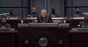 Movie still from “Bicentennial Man” (1999), directed by Chris Columbus – A man sitting in front of two other men in a courtroom; Medium shot, Low angle