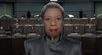 Movie still from “Bicentennial Man” (1999), directed by Chris Columbus – An image of a woman in front of a group of people; Close Up shot, Low angle