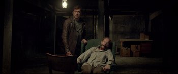Two men are sitting in a chair in a room