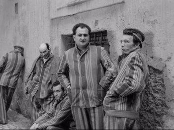 Movie still from “Big Deal on Madonna Street” (1958), directed by Mario Monicelli – A black and white photo of a group of men in striped pajamas; Medium shot, High angle