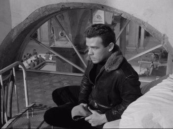 Movie still from “Big Deal on Madonna Street” (1958), directed by Mario Monicelli – Black and white photograph of a man in a leather jacket; Medium shot, High angle