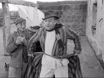 Movie still from “Big Deal on Madonna Street” (1958), directed by Mario Monicelli – A man in a hat is holding a towel; Medium shot, Low angle