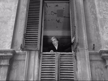 Movie still from “Big Deal on Madonna Street” (1958), directed by Mario Monicelli – An old photo of a woman looking out of a window; Medium shot, Low angle