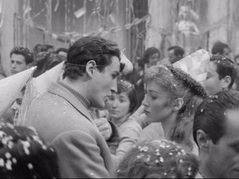 Movie still from “Big Deal on Madonna Street” (1958), directed by Mario Monicelli – A man and a woman are standing in a crowd; Medium shot, High angle