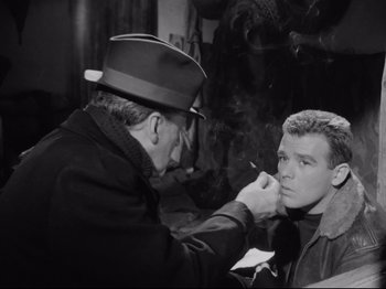 Movie still from “Big Deal on Madonna Street” (1958), directed by Mario Monicelli – An older man is painting a younger man's face; Medium shot, Over the shoulder angle