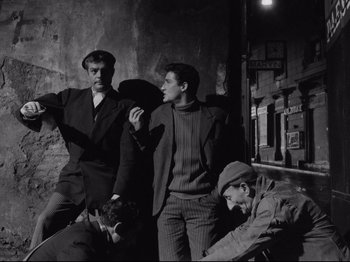 Movie still from “Big Deal on Madonna Street” (1958), directed by Mario Monicelli – A group of men standing next to each other in a room; Medium shot, Low angle