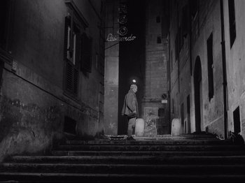 Movie still from “Big Deal on Madonna Street” (1958), directed by Mario Monicelli – A man walking down the steps of a building; Wide shot, High angle
